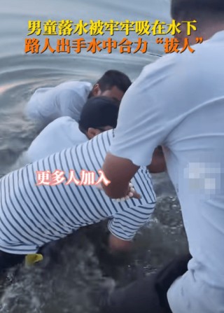 男孩被水流吸住 众人合力拔人，众人齐心救援彰显人间大爱